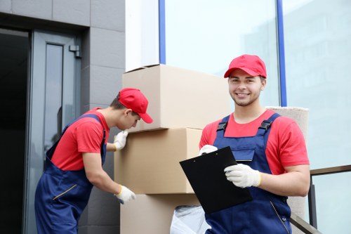 Removalists carrying furniture through a narrow stairwell in Haringey