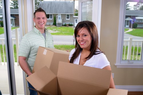 Professional movers carrying furniture through a narrow hallway