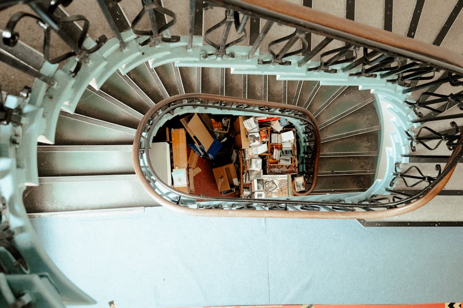 Photograph of an interior stairwell within a residential property, showing a narrow, steep staircase with wooden steps leading upwards. The stairs are surrounded by exposed wooden framing and unfinish